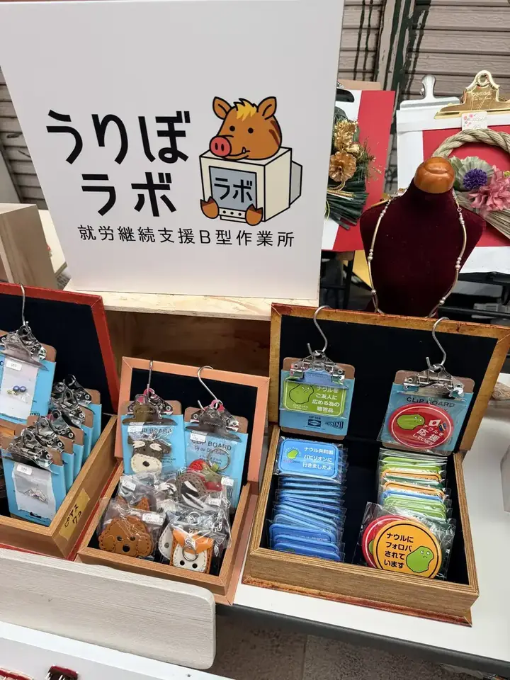 マルシェの売場。ピアス、レザーのキーホルダー、ナウル共和国の缶バッジをクリップボードで陳列